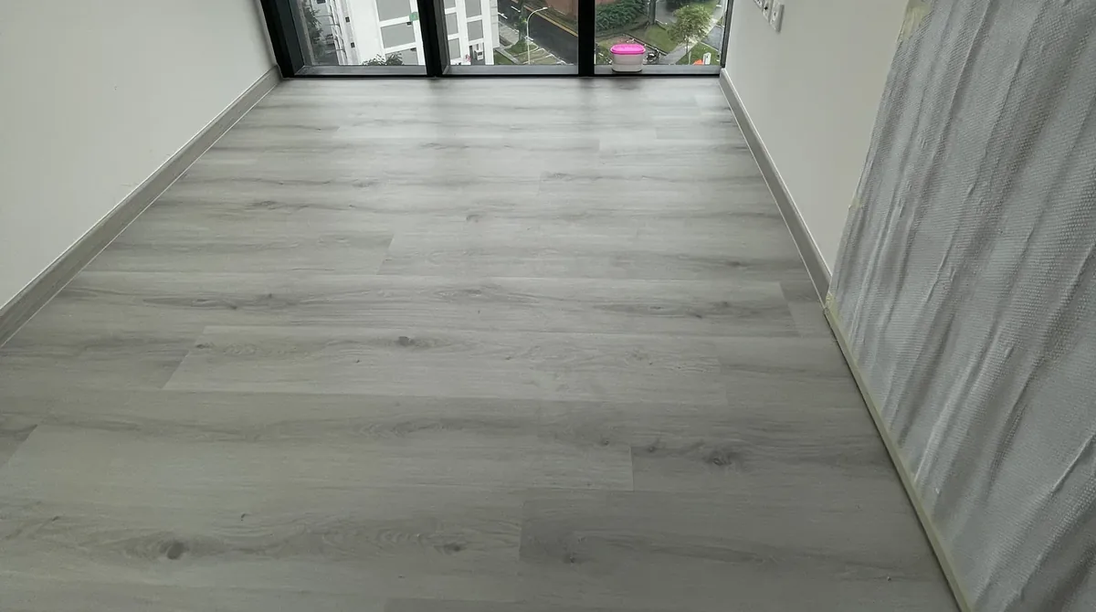 Light grey wood-look LVT vinyl planks laid in a Singapore condominium bedroom by LN Flooring