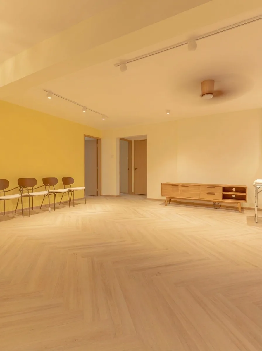 Herringbone vinyl flooring in a Singapore HDB living room with yellow accent wall