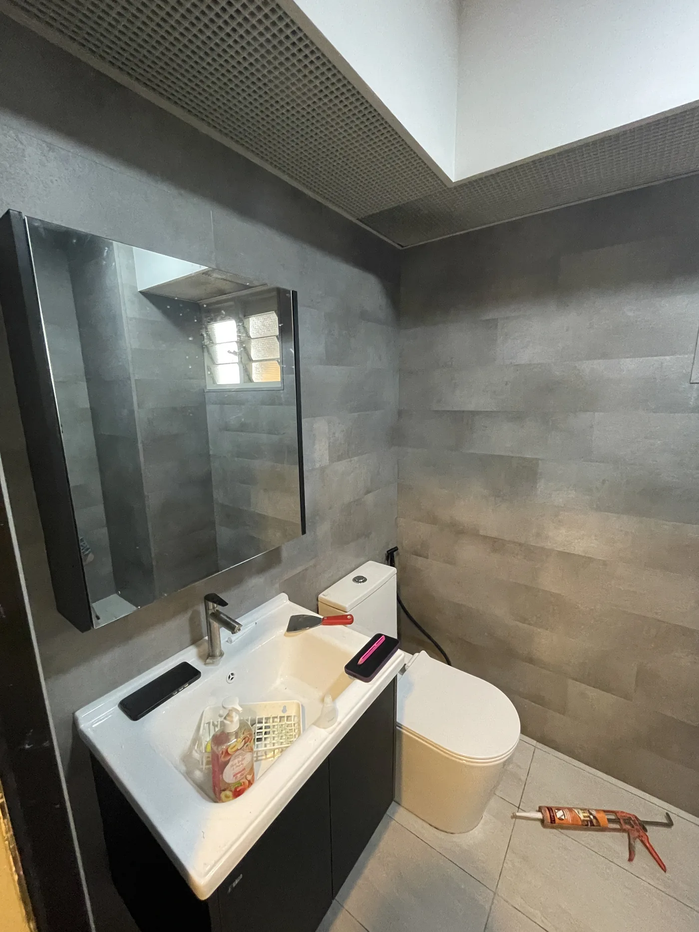 Completed HDB bathroom with a tiled floor, walls in vinyl plank, by LN Flooring in Singapore