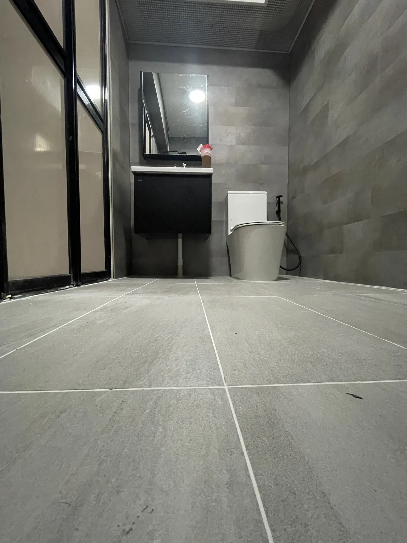Finished bathroom with glass screen and modern fittings, tiled by LN Flooring