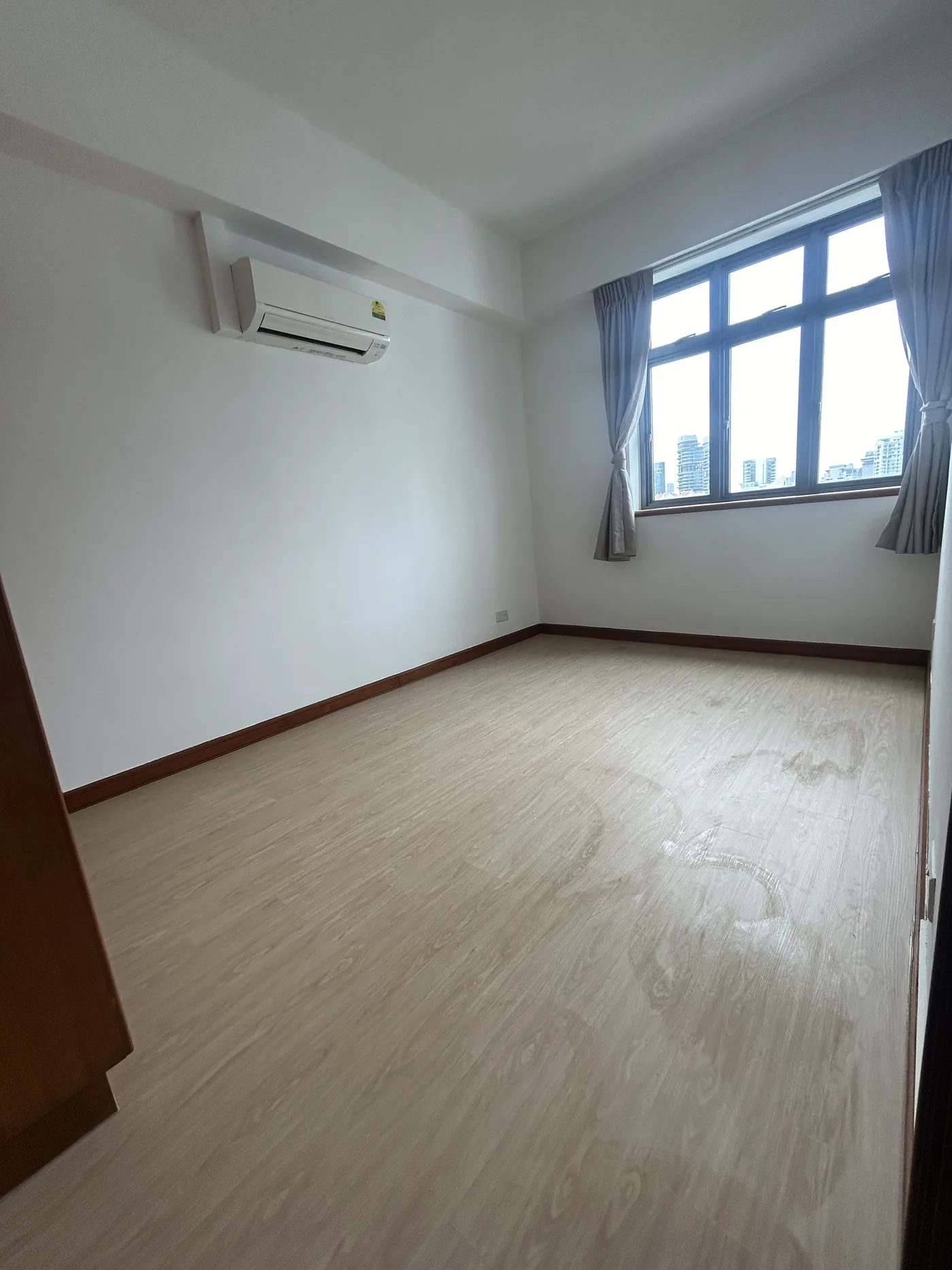 Pale wood-look LVT vinyl flooring in a finished Singapore condominium bedroom