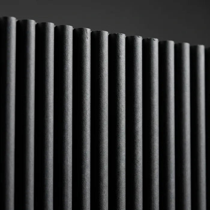 Close-up of a charcoal PVC composite fluted wall panel showing the rounded rib profile