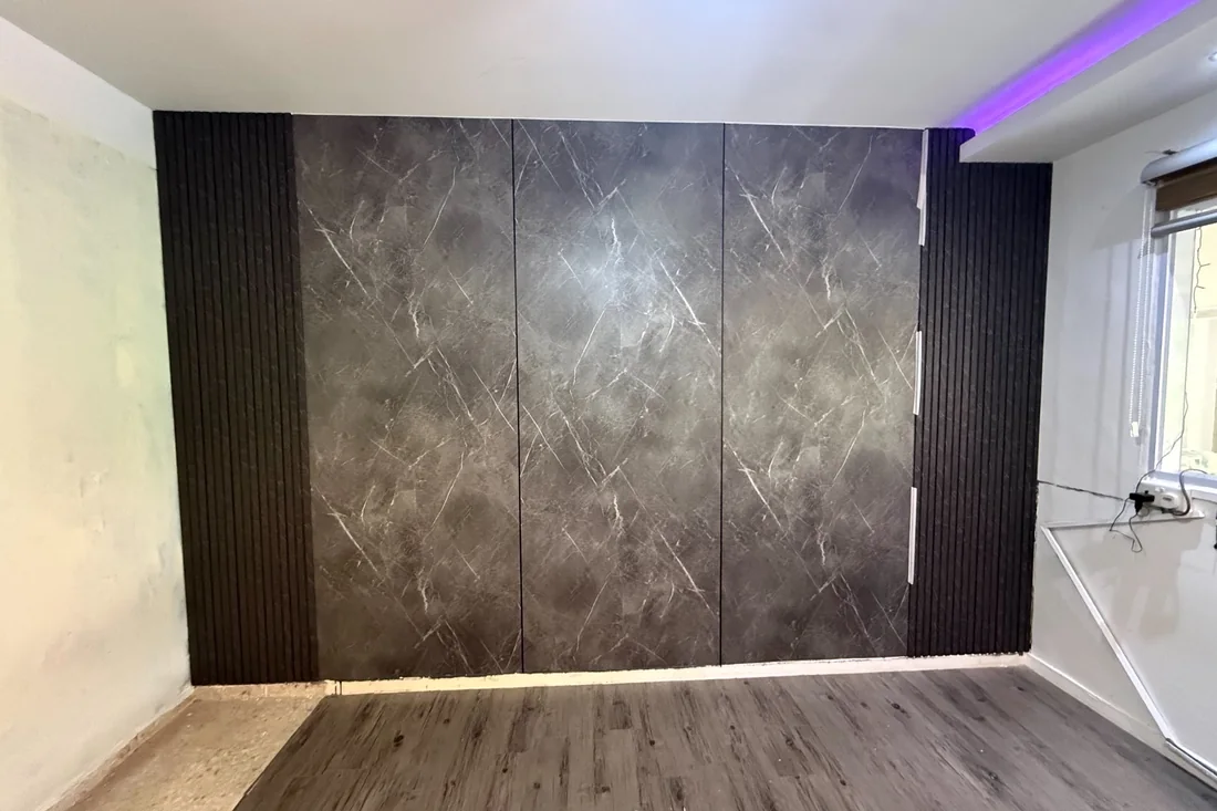 Dark stone-effect wall panels with black fluted edging in a Singapore flat